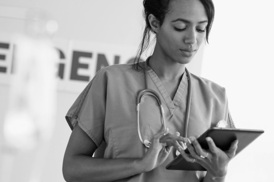 Technician holding iPad, black and white.