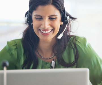 Customer service representative smiling with a headset on.