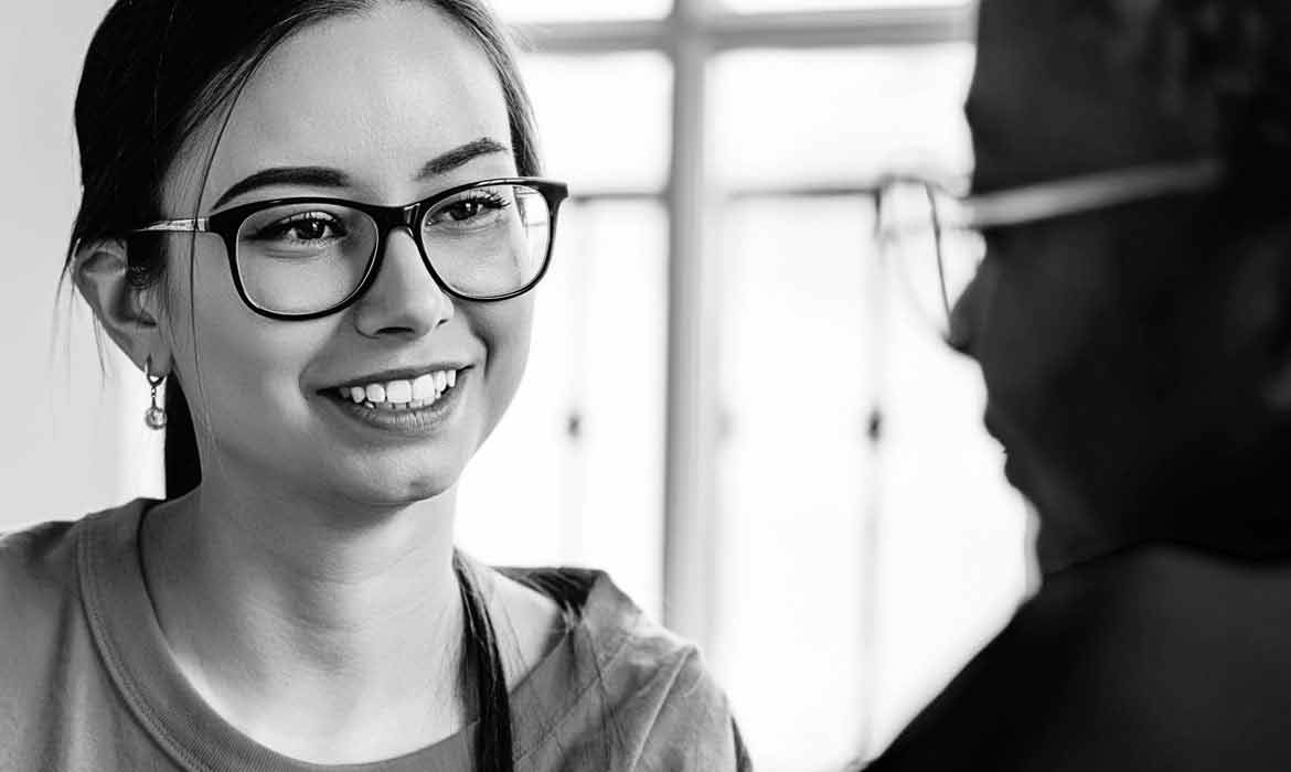 Woman with glasses talking to man.