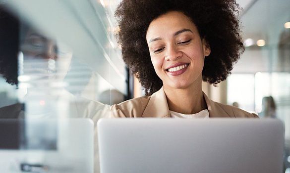 A woman uses a laptop to attend an online webinar.