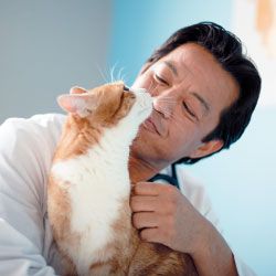 man holding orange and white cat.