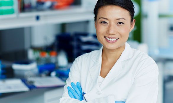 Friendly female laboratory technician with arms crossed