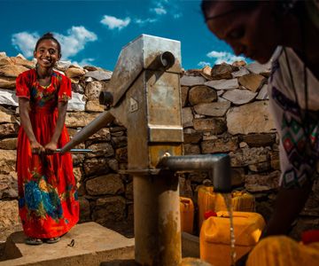 A girl at a water pump.