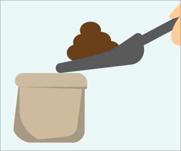 Hand holding pooper scooper above brown bag