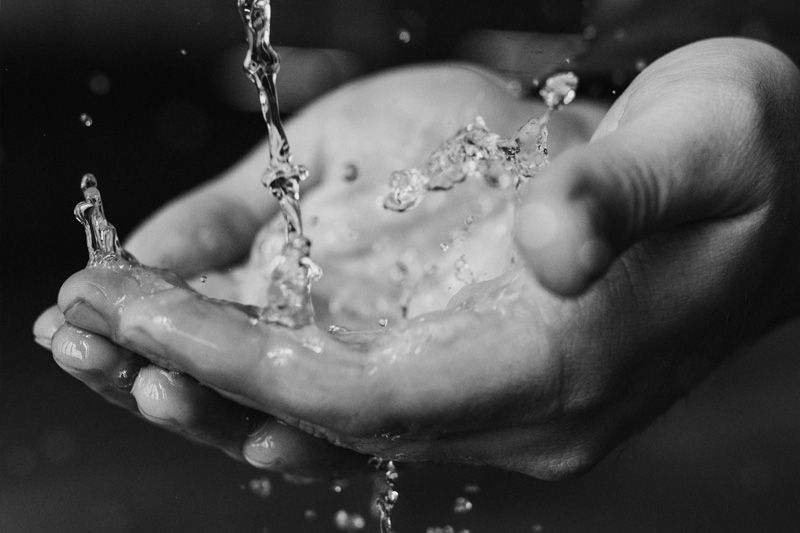 Cupped hands catching water.