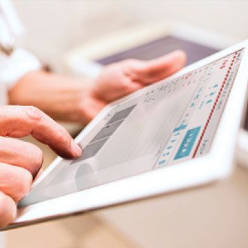 A vet reviewing the urinalysis report displayed on a tablet