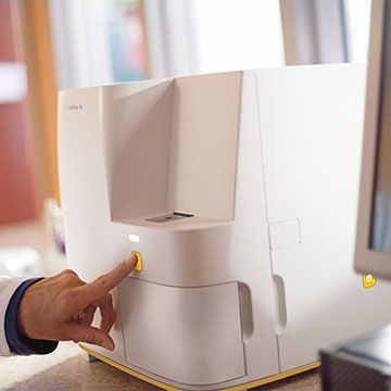 Veterinarian pushing the button of the SediVue Dx analzer