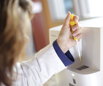 Technician dispensing the sample into the SediVue Dx urine sediment analyzer.