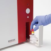 Gloved hand loading a blood sample into the ProCyte Dx analyzer